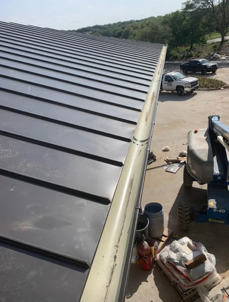 Standing seam panel and gutter detail on a metal roofing jobsite in Greenville